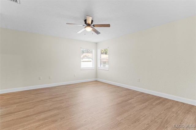 spare room with ceiling fan and light wood-type flooring