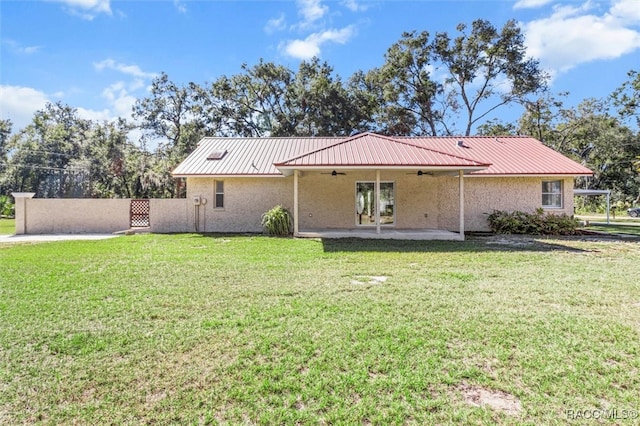 back of property featuring a yard, ceiling fan, and a patio area