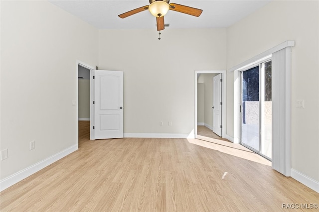 spare room with ceiling fan, a towering ceiling, and light hardwood / wood-style flooring