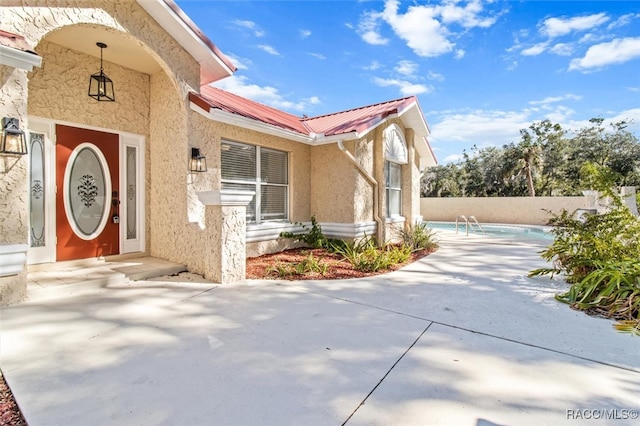 view of exterior entry with a patio area