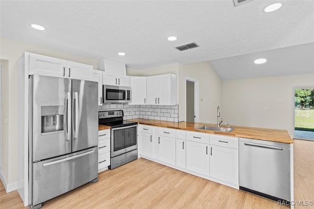 kitchen featuring sink, white cabinets, wooden counters, and appliances with stainless steel finishes