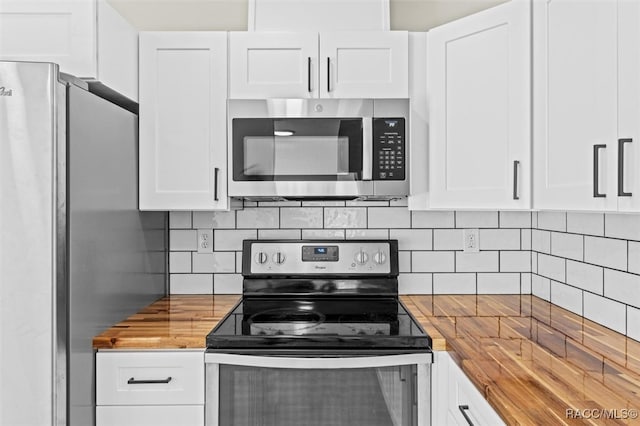 kitchen with backsplash, butcher block counters, white cabinets, and stainless steel appliances