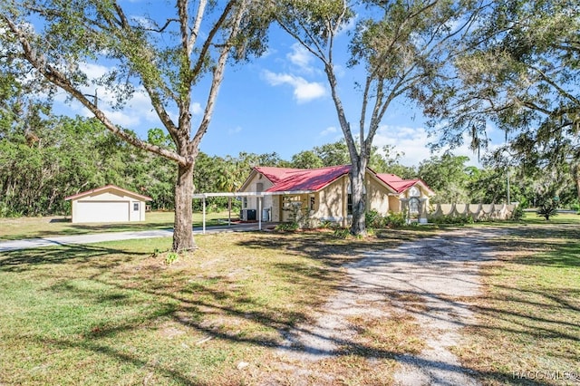 view of front of home featuring a front yard, a garage, an outdoor structure, and a carport