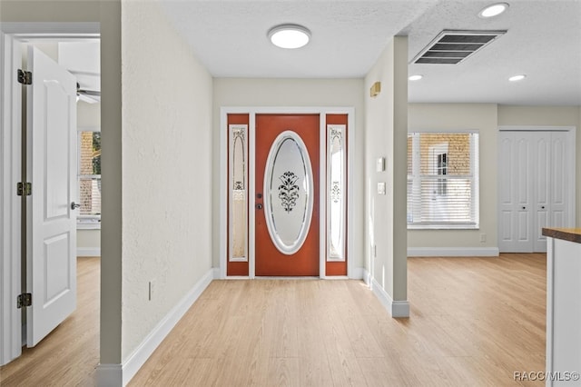 foyer entrance with ceiling fan and light hardwood / wood-style flooring