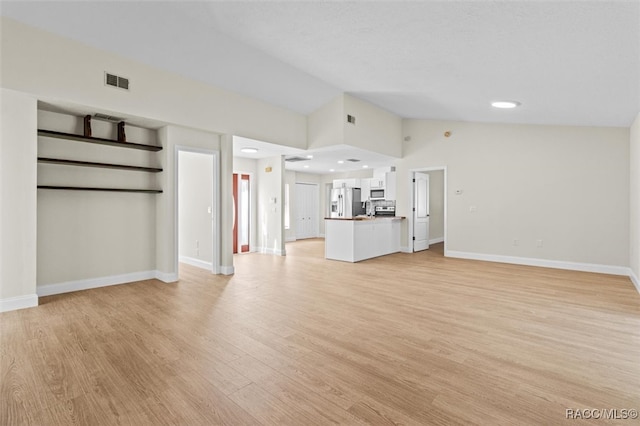 unfurnished living room featuring light wood-type flooring and high vaulted ceiling