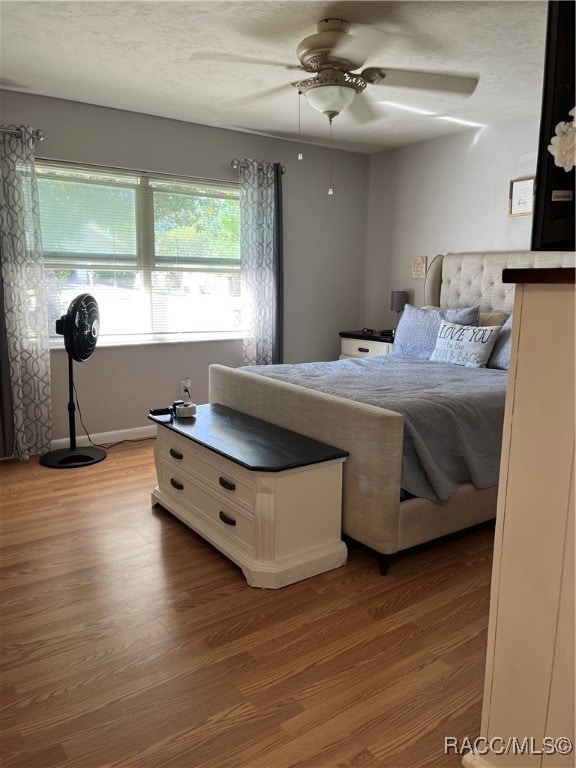 bedroom featuring a textured ceiling, light hardwood / wood-style floors, and ceiling fan