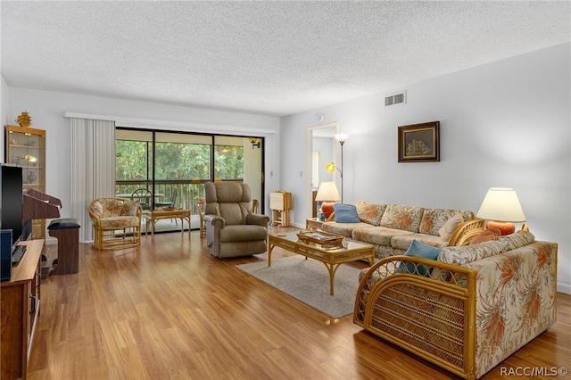 living room with light wood-type flooring and a textured ceiling