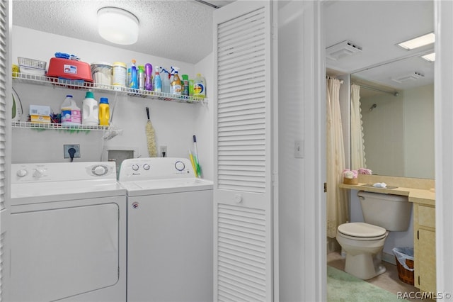 washroom with separate washer and dryer and a textured ceiling