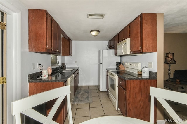 kitchen featuring white appliances, sink, and light tile patterned floors