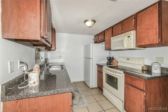 kitchen featuring light tile patterned flooring, white appliances, and sink