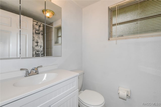 bathroom featuring a shower with curtain, vanity, and toilet