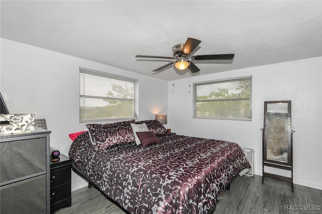 bedroom featuring dark hardwood / wood-style floors, multiple windows, and ceiling fan