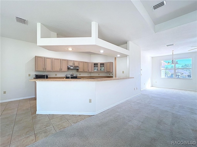 kitchen featuring vaulted ceiling, stainless steel range with electric stovetop, visible vents, and under cabinet range hood