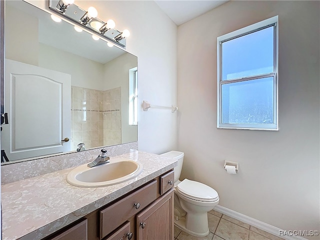 bathroom featuring toilet, tile patterned flooring, a shower, baseboards, and vanity