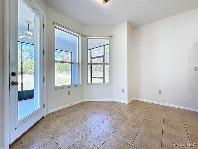 empty room featuring baseboards and light tile patterned flooring