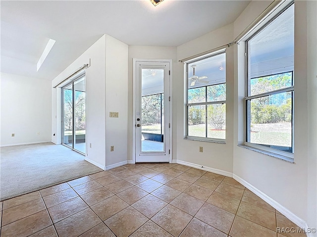 doorway with baseboards, light colored carpet, and light tile patterned flooring