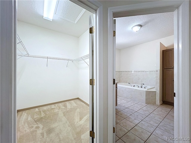 spacious closet with light tile patterned floors and light colored carpet