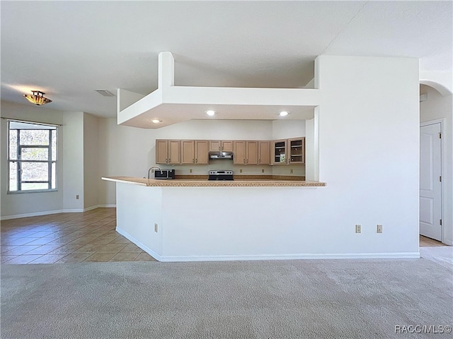 kitchen with visible vents, under cabinet range hood, light colored carpet, stainless steel range with electric stovetop, and light tile patterned flooring