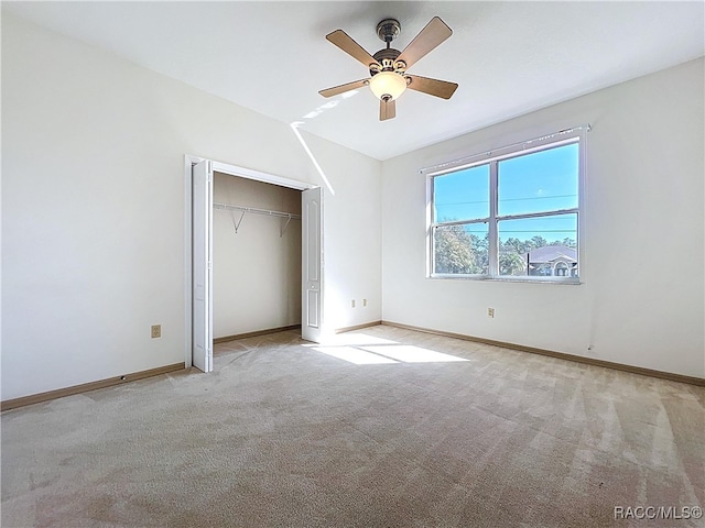 unfurnished bedroom featuring a closet, vaulted ceiling, baseboards, and carpet floors