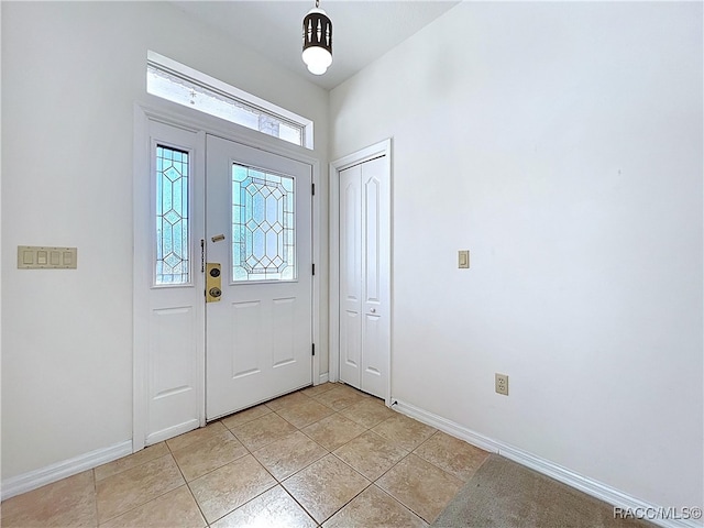 entrance foyer with light tile patterned flooring and baseboards