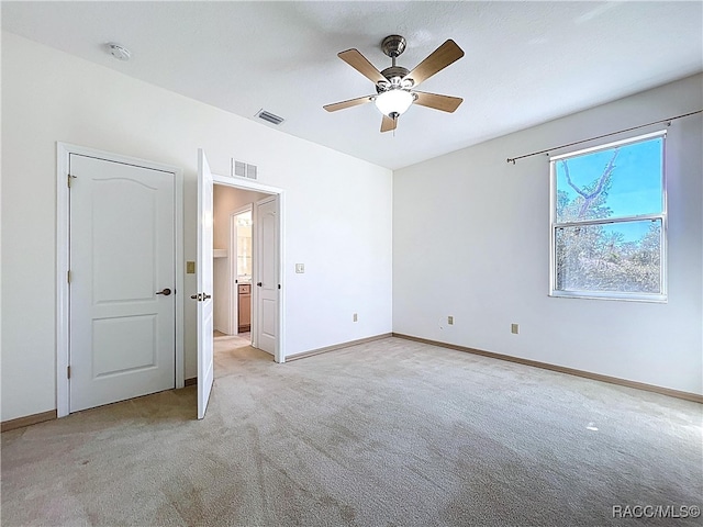 unfurnished bedroom featuring visible vents, light carpet, and baseboards