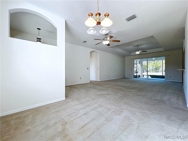 carpeted spare room featuring visible vents, baseboards, ceiling fan with notable chandelier, a textured ceiling, and a raised ceiling