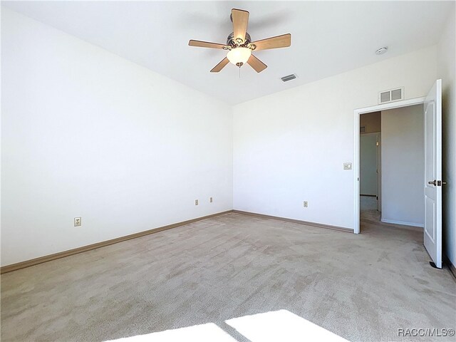 unfurnished room featuring a ceiling fan, carpet, visible vents, and baseboards