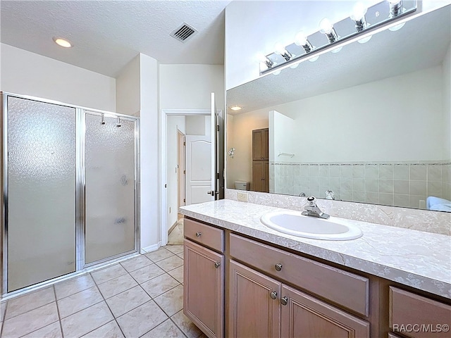 bathroom featuring tile patterned flooring, a shower stall, vanity, and visible vents