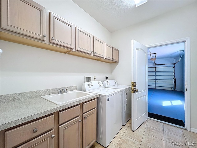 laundry area with washer and clothes dryer, cabinet space, light tile patterned flooring, and a sink