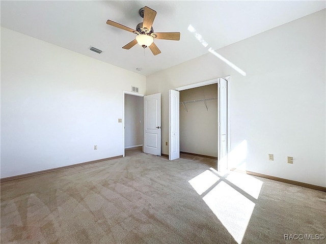 unfurnished bedroom with a closet, visible vents, light colored carpet, and baseboards