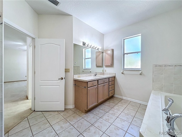 full bath with vanity, visible vents, tile patterned flooring, and a textured ceiling