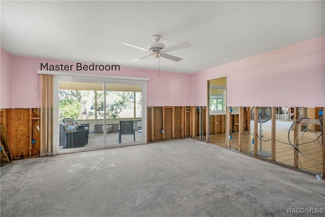 spare room with a ceiling fan and unfinished concrete floors