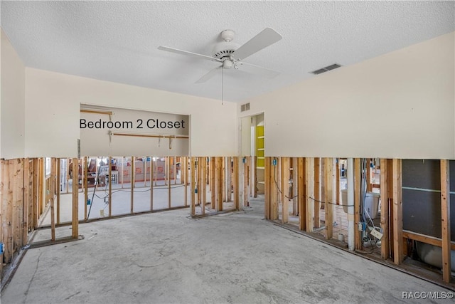 unfurnished room with a ceiling fan, visible vents, and a textured ceiling