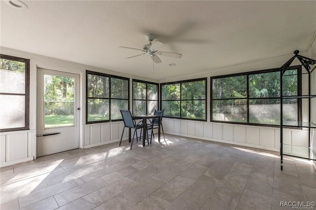 unfurnished sunroom with ceiling fan