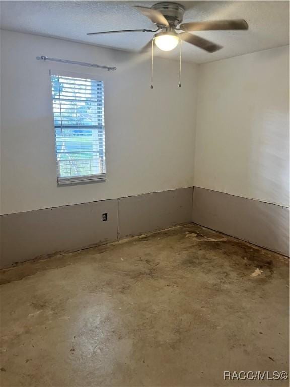 spare room with ceiling fan and concrete flooring