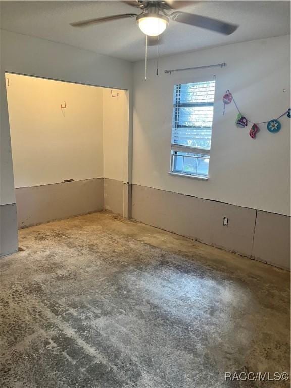 spare room featuring ceiling fan and concrete flooring