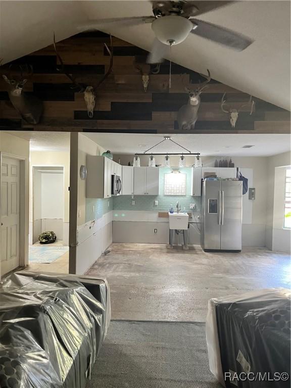 basement featuring stainless steel fridge and ceiling fan