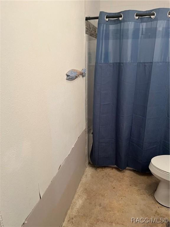 bathroom with toilet and curtained shower