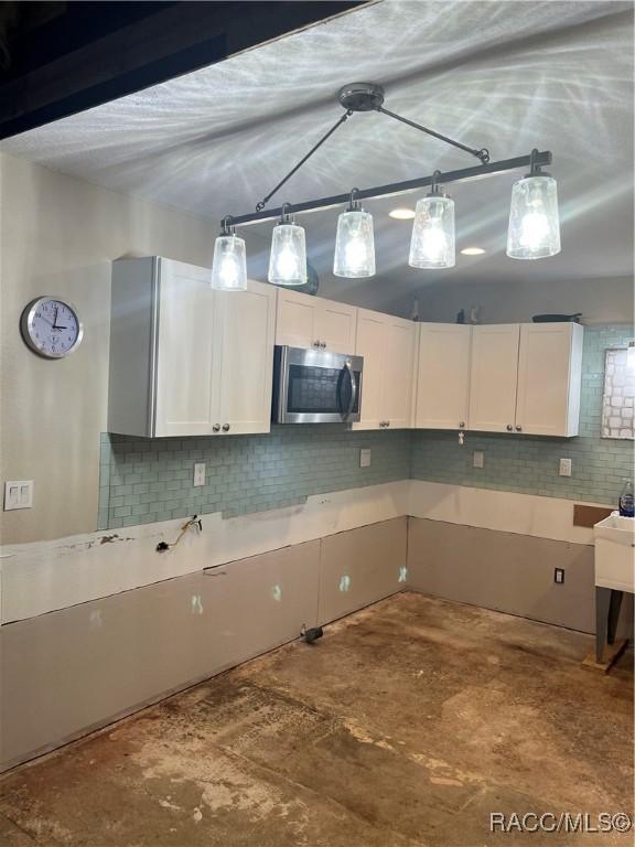 kitchen featuring decorative backsplash and white cabinetry