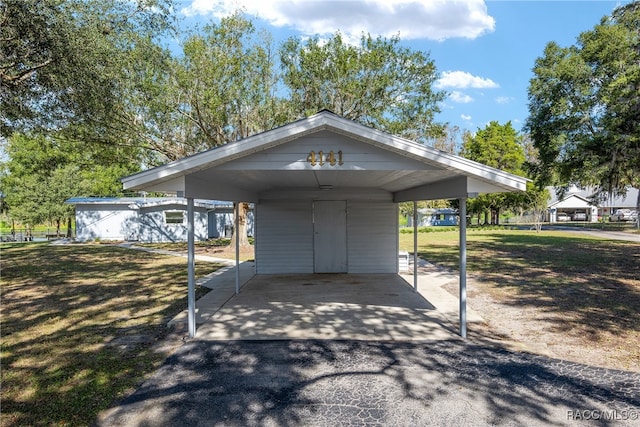 view of parking / parking lot featuring a carport and a lawn