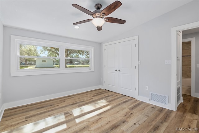 unfurnished bedroom featuring a closet, light hardwood / wood-style flooring, and ceiling fan