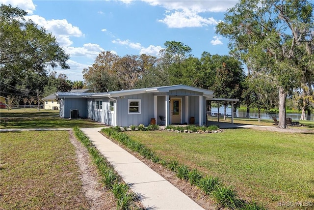 view of front of home featuring central air condition unit, a front yard, and a carport