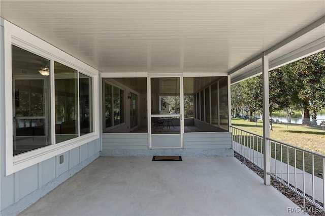 view of patio / terrace with a water view and a sunroom