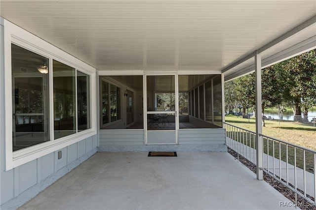 view of patio featuring a water view and a sunroom