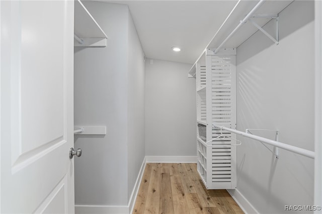 walk in closet with light hardwood / wood-style floors