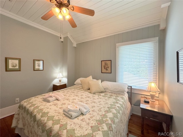 bedroom with crown molding, ceiling fan, dark wood-type flooring, and wood walls