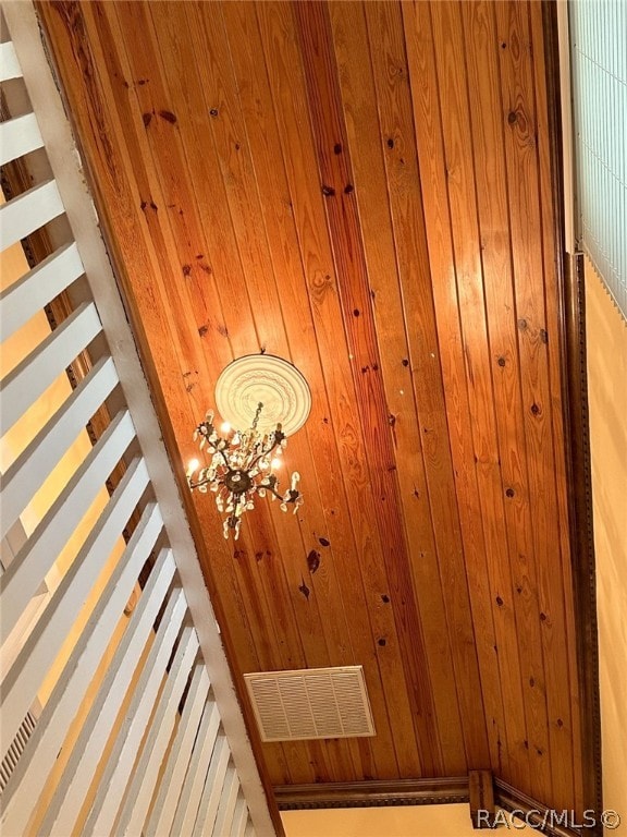 room details featuring wood walls and a chandelier