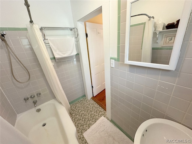 bathroom with shower / tub combo and tile walls