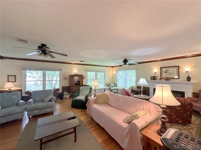 living room with hardwood / wood-style floors, a healthy amount of sunlight, and ornamental molding