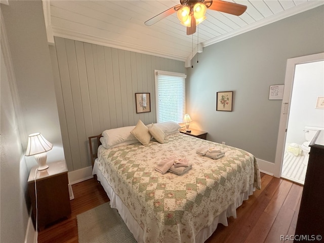 bedroom featuring ceiling fan, hardwood / wood-style floors, wood walls, and ornamental molding